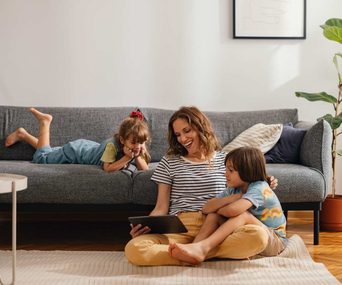 Resident with her kids in the apartment living area at Archer Court in Gainesville, Florida