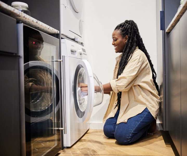 Resident using laundry facility provided at Ochlockonee Pointe Apartments in Midway, Florida