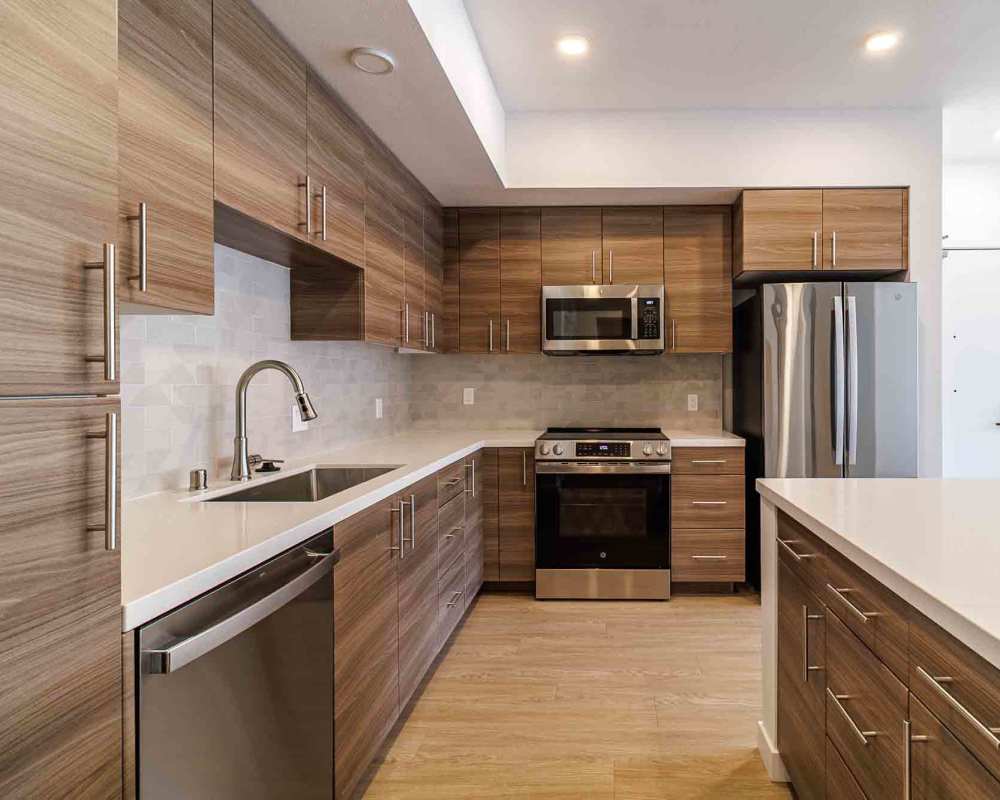 Contemporary kitchen with wooden cabinets, stainless steel appliances, and a modern design at Sutter Green Apartments in Sacramento, California.