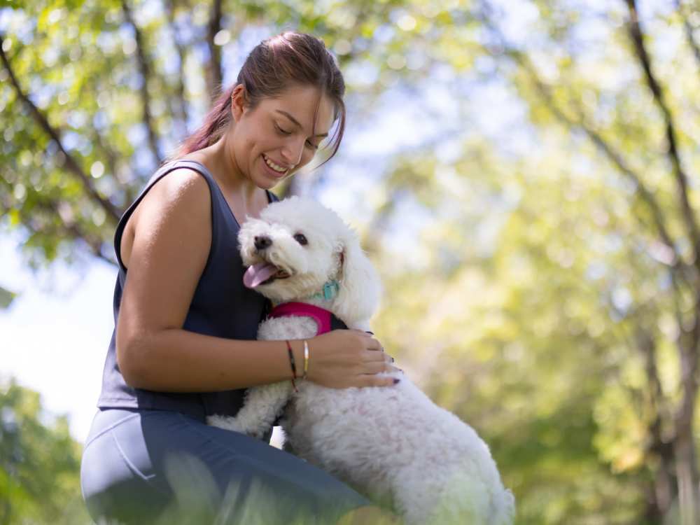 A resident hugging her pet dog in a park near The Reserve at Brookhaven in Palm Coast, Florida 