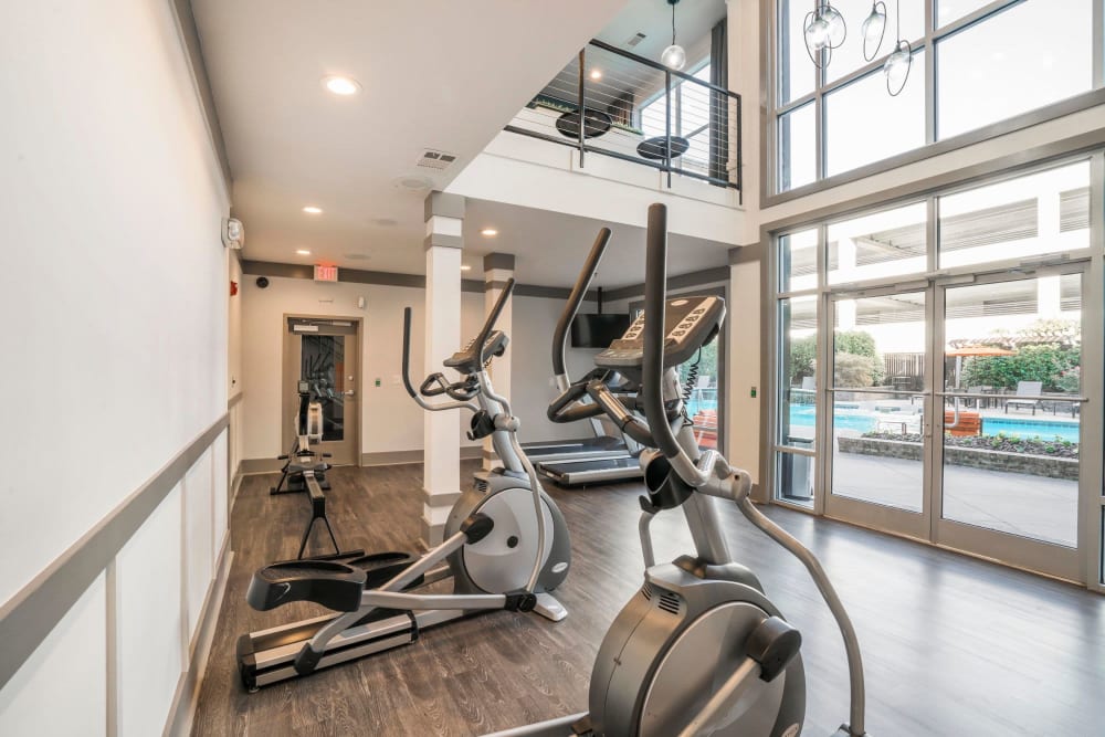 High ceilings and ample exercise equipment at the onsite fitness center at Two Blocks Apartments in Dunwoody, Georgia