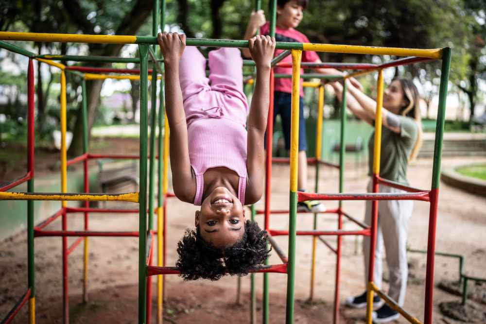 Resident child hanging upside down in the playground  at Vintage At 50th in Oklahoma City, Oklahoma