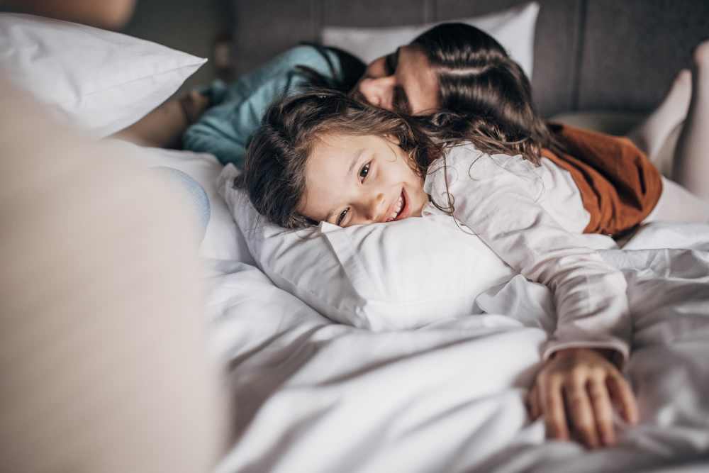 Mother and her daughter on a bed in the apartment at Sherwood Pointe Apartments in Shawnee, Oklahoma