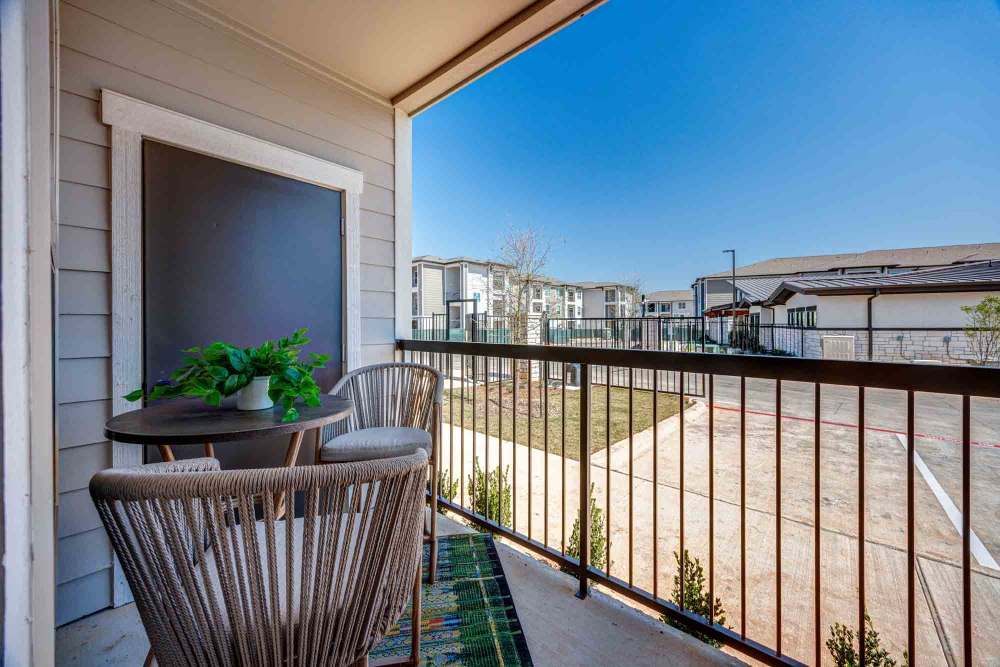 Small patio table and chairs sit on a balcony at The Abbey at Veramendi in New Braunfels, Texas