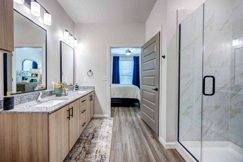 Double vanity with granite countertops in a light-toned bathroom at The Abbey at Veramendi in New Braunfels, Texas