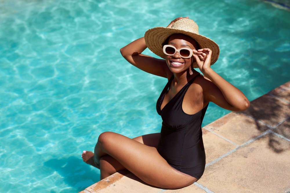 Women sitting on the edge of the pool at Athena Garden Apartments in Athens, Texas