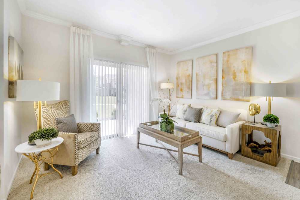 Well-lit living room with a comfortable couch and a large sliding door at Eastland Trails in Independence, Missouri