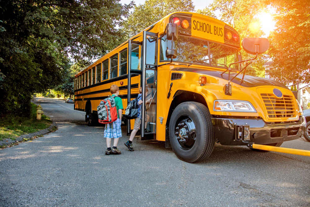 Residents boarding school bus at Corrigan Square Apartments in Gaithersburg, Maryland