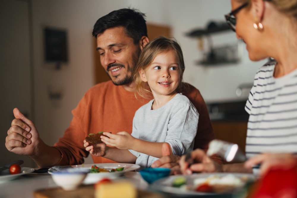 Family enjoying a meal together in a modern kitchen with warm lighting and casual atmosphere at Mapleton Properties in Indianapolis, Indiana