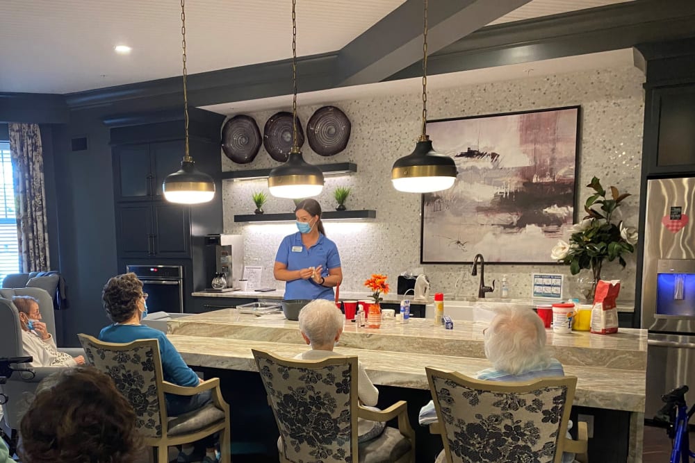 Masked nurse talking to a group of residents in a cafe at a Anthology of Edmonds location