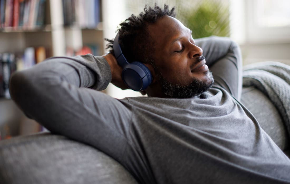 Man relaxing and listening to music through headphones at The Collection Townhomes in Dallas, Texas