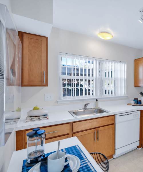 Eat-in kitchen with a dishwasher and stainless-steel sink at Muirwood in Farmington Hills, Michigan
