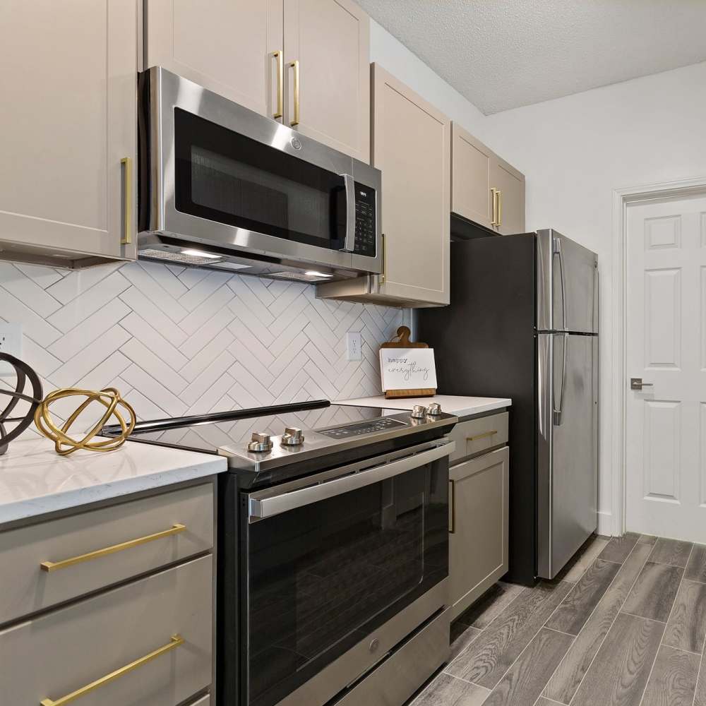 Kitchen with range, refrigerator and wooden cabinets at The Ashton in Raleigh, North Carolina