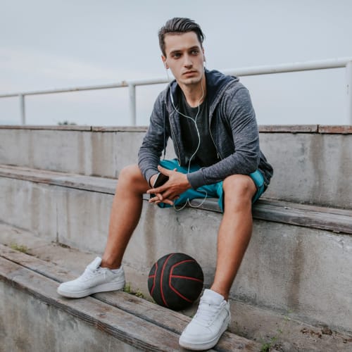 A resident sitting with a basketball at Fairway Heights in Twentynine Palms, California