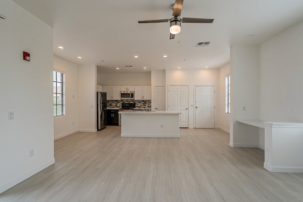 Bright model kitchen and living room with hardwood floors at Main Street Lofts at Verrado in Buckeye, Arizona