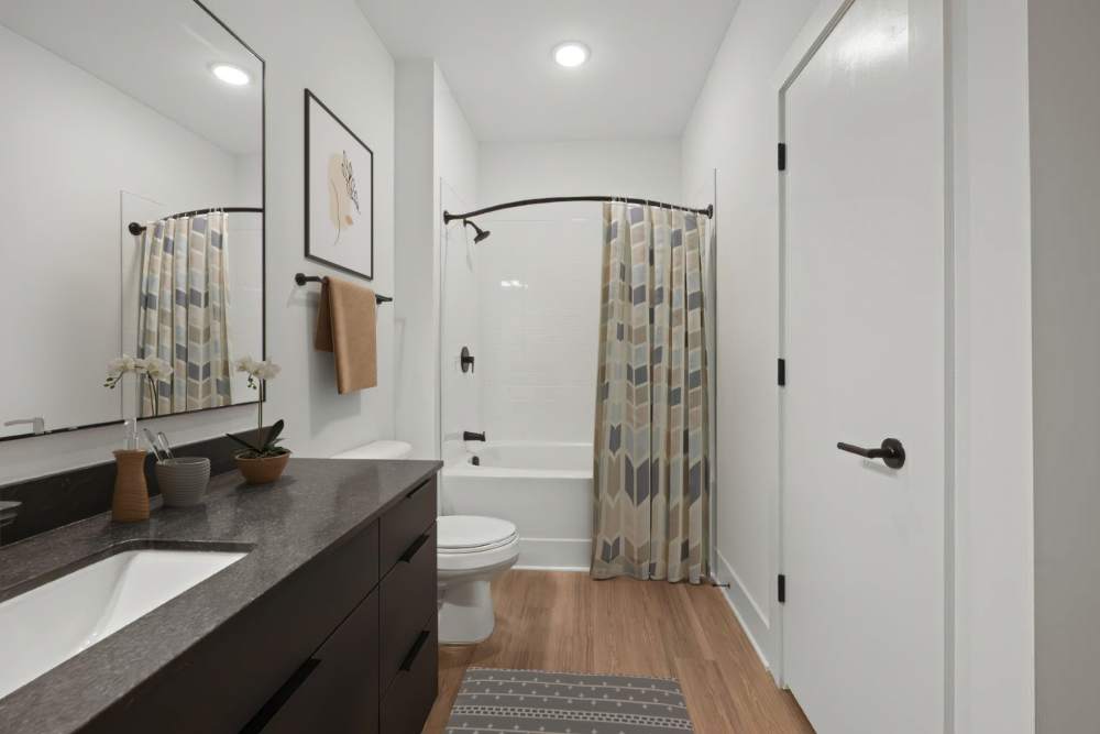 Bathroom with custom cabinetry and wood-style flooring at The Scottie in Nashville, Tennessee