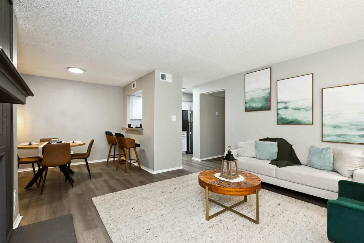 Model living and dining space with fireplace and kitchen bar at Creekside in San Angelo, Texas