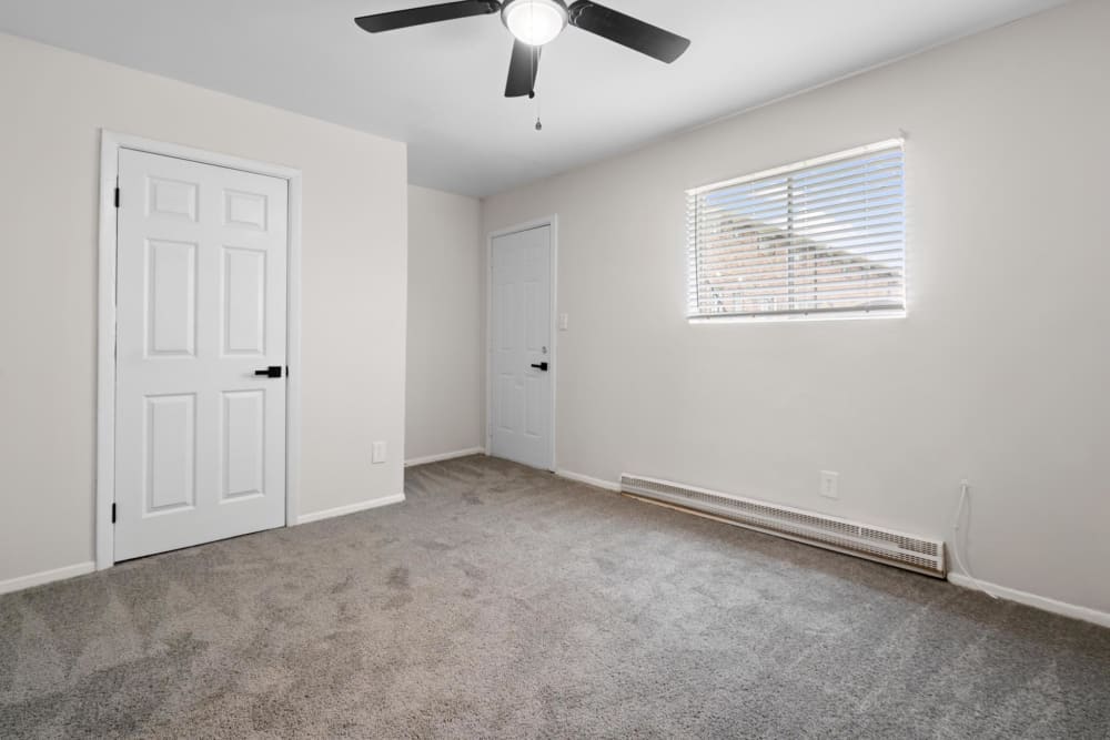 Plush carpeting and a ceiling fan in an apartment bedroom at Cobbs Creek Apartment Homes in Decatur, Georgia
