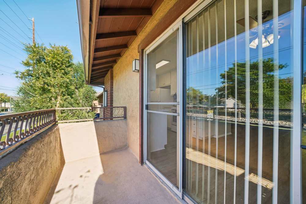 Private balcony with sliding glass door and outdoor view at Casa Sierra Apartments in Riverside, California