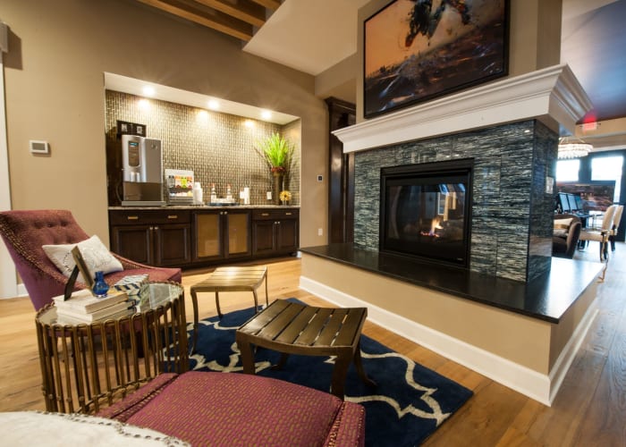 Fireplace with comfortable seating in the clubhouse at Clifton Park Apartment Homes in New Albany, Ohio