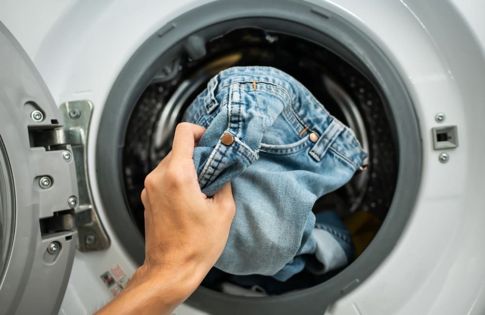 Resident taking some jeans hot from the dryer in her apartment at Slauson Village in Culver City, California