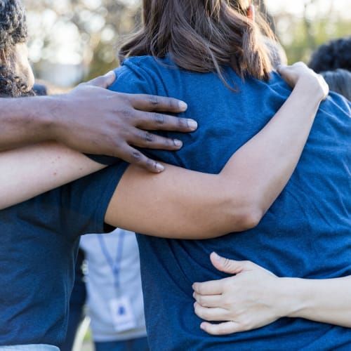 People embracing during charitable work that North County Self Storage takes part in