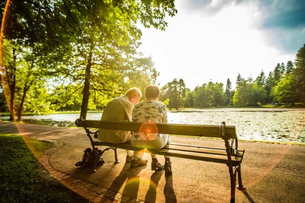 Elderly Couple Sitting On Park Bench near The Abbey at Preserve Way in Tomball and The Woodlands TX