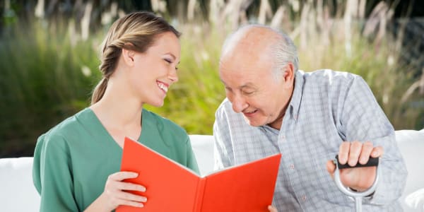 Caregiver reading to a memory care resident at Transitions At Home in Elkhorn, Wisconsin