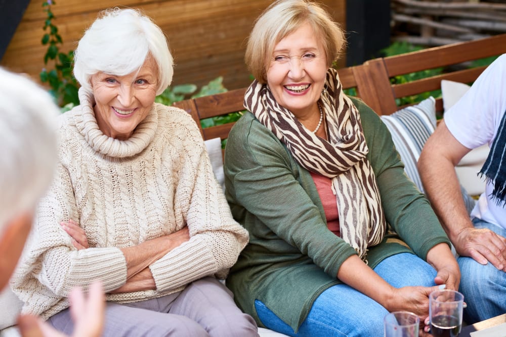 A group of seniors enjoying a glass of wine at Brightwater Senior Living of Highland in Highland, California