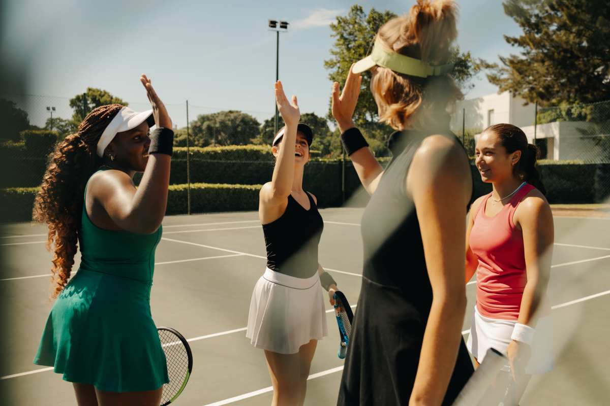 Group of women celebrating on a tennis court in sunlight at Colony Parc in Ventura, California