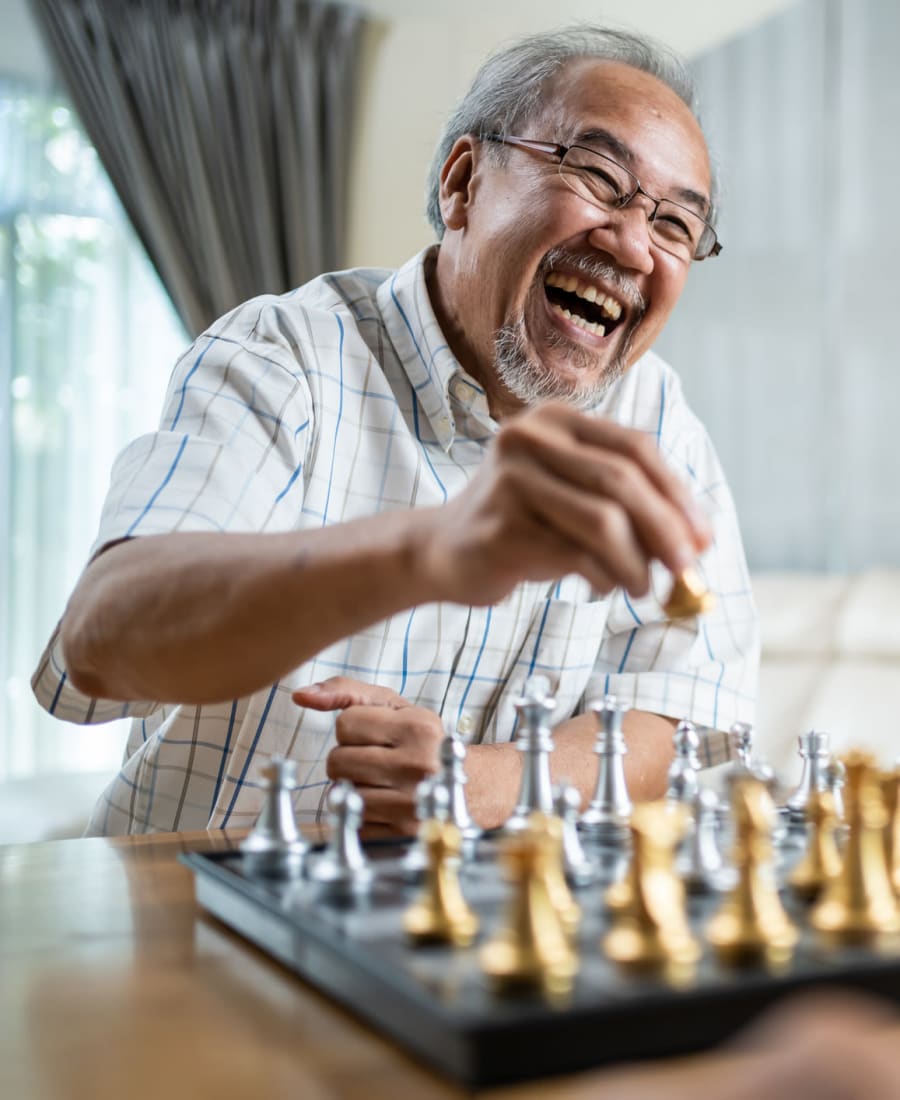 Resident playing chess at The Courtyards at Linden Pointe in Winnipeg, Manitoba
