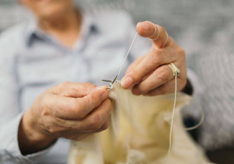 Senior sewing clothes by hand at Tuscany at McCormick Ranch in Scottsdale, Arizona