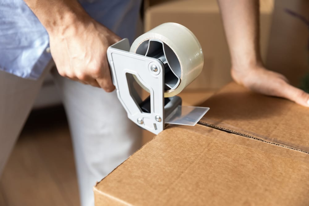 A box being closed with packing tape at A-American Self Storage