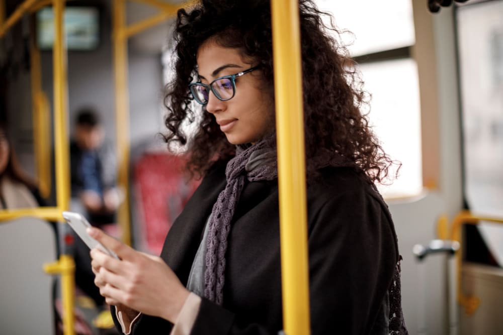 Woman sitting on the bus listening to music on her phone near The Main in Evanston, Illinois 