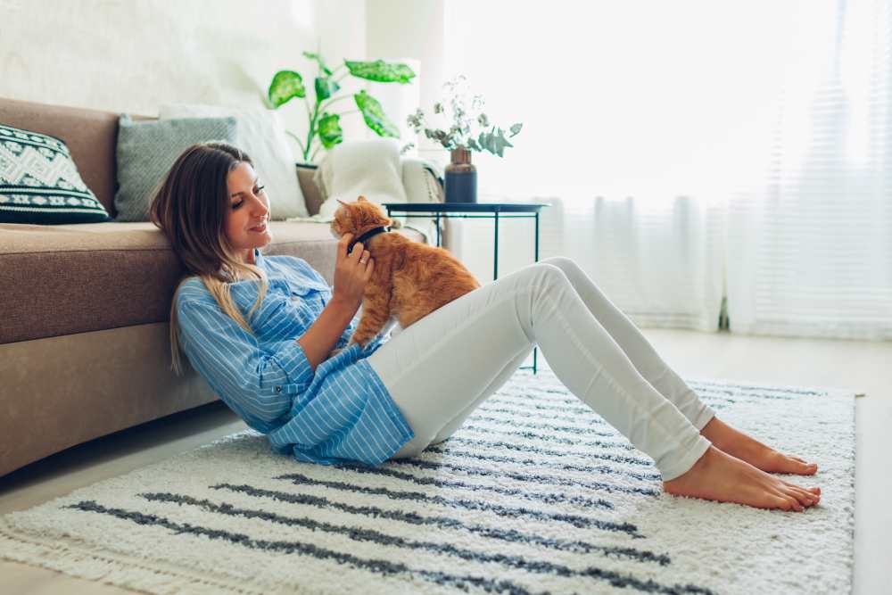 Resident woman playing with pet in her living room at Smallwood Gardens in Waldorf, Maryland