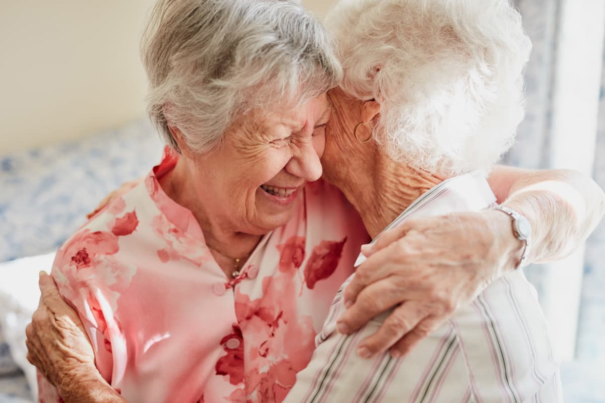 Two residents hugging at Sandpiper Courtyard in Mt. Pleasant, South Carolina