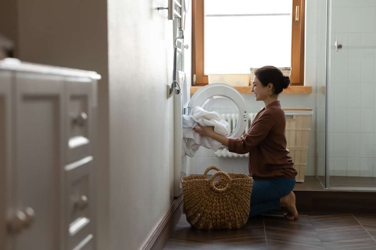 Man putting laundry in the washer at Uptown La Grange in La Grange, Illinois