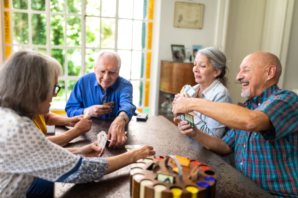 Residents laughing and playing a game at CERTUS Premier Memory Care Living in Vero Beach, Florida.