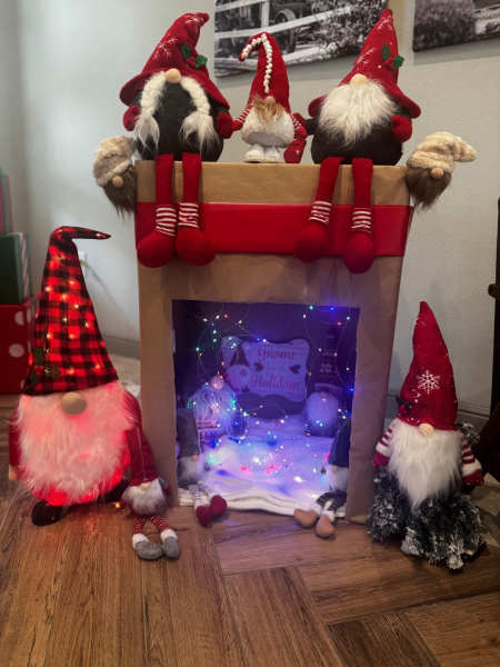 A box decorated with gnomes to look like a fireplace.