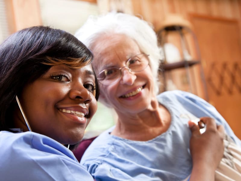 Resident being assisted by a caretaker to walk downstairs at Retirement Ranch in Clovis, New Mexico