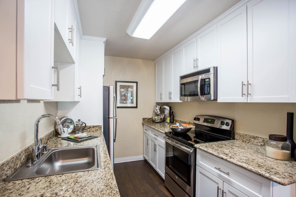 Modern kitchen with granite countertops and stainless-steel appliances in a model home at Valley Plaza Villages in Pleasanton, California