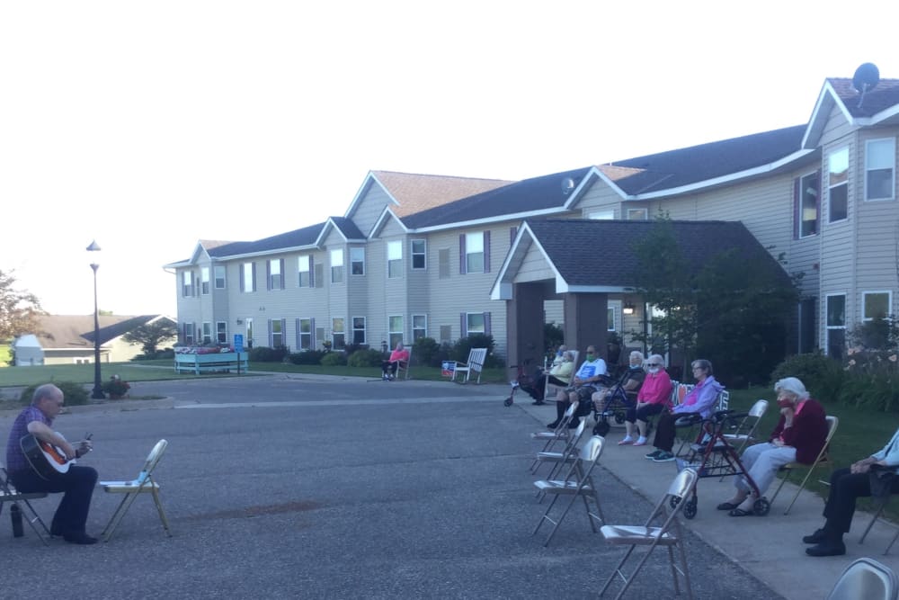 Resident sitting oustide to listen to music at Whispering Oak Place in Ellendale, Minnesota