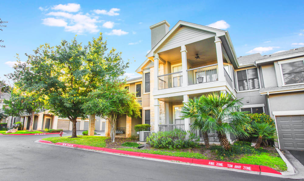 Beautifully maintained landscaping outside resident buildings at Riata Austin in Austin, Texas