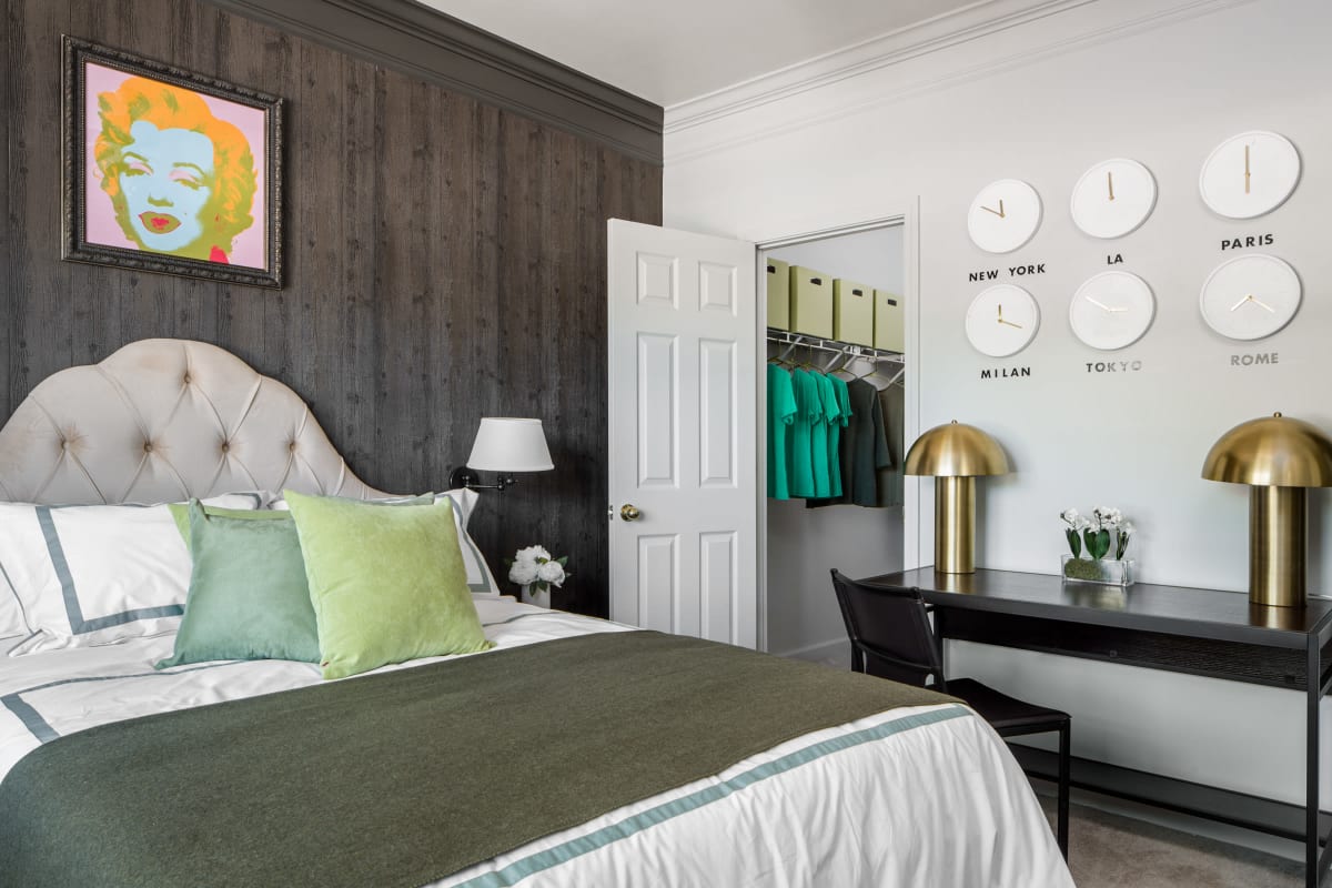 Elegant model bedroom with a desk and walk-in closet at The George in Statesboro, Georgia