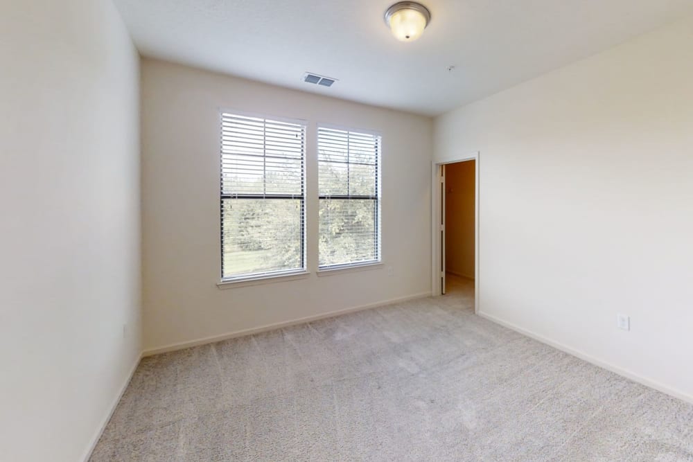 A bedroom with two large windows for natural lighting at The Hawthorne in Jacksonville, Florida