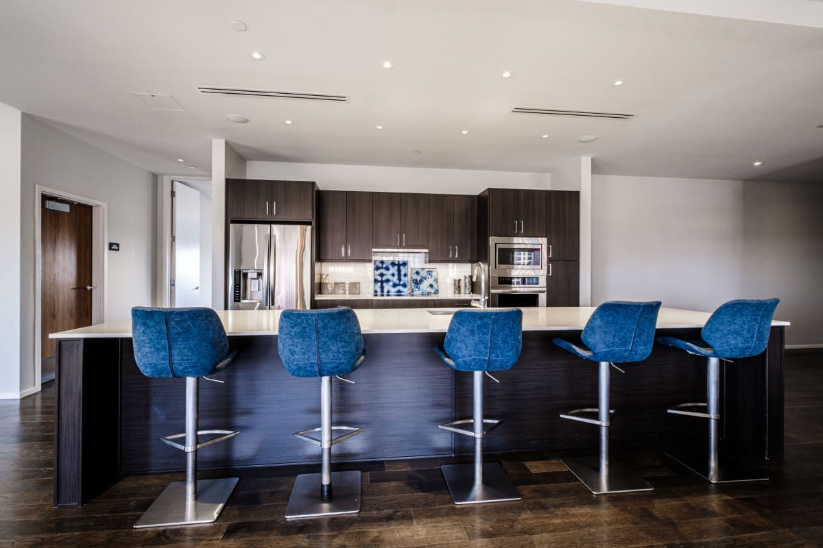 Kitchen island with bar seating in an apartment kitchen at The Statler Residences, Dallas, Texas
