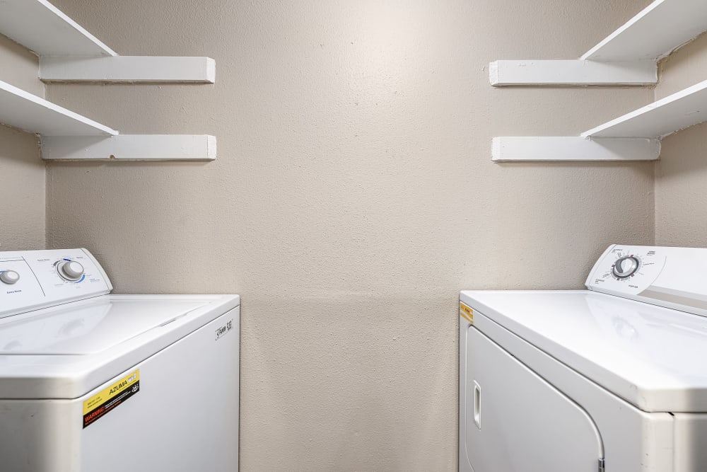 Laundry area with washer, dryer and shelving at Austin Midtown in Austin, Texas