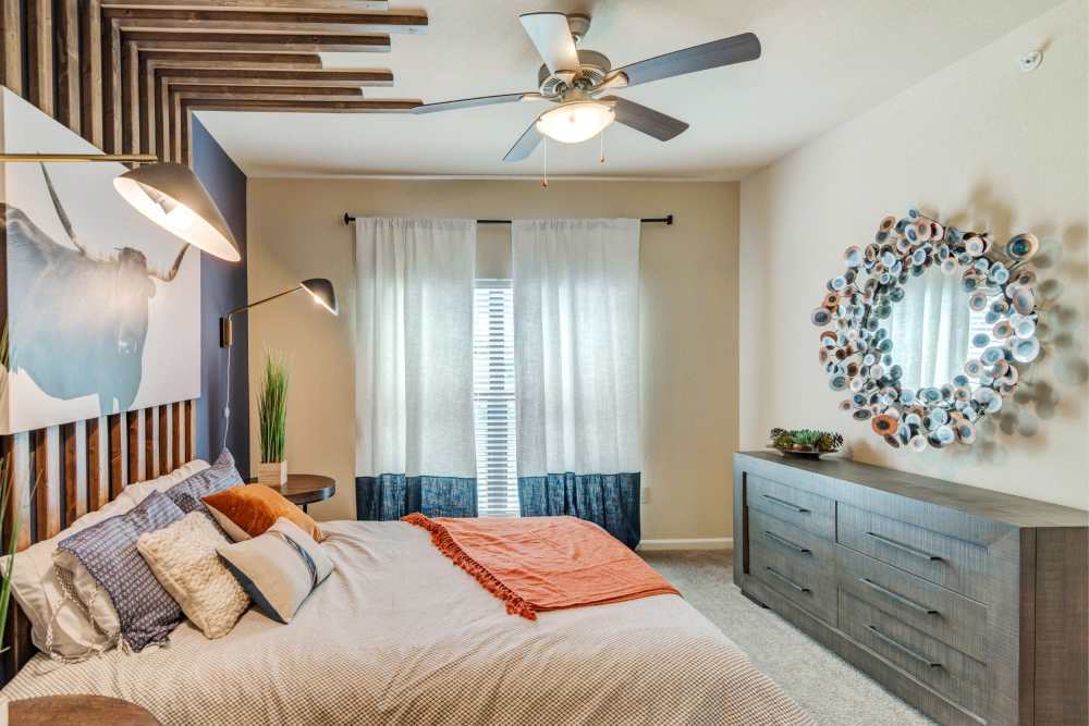 Three-Bedroom Luxury Apartments In South Austin, TX - Landing at Double Creek - Spacious Bedroom With Plush Carpeting, A Ceiling Fan, And A Large Window.