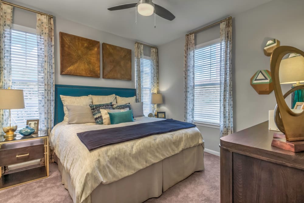 Plush carpeting and a ceiling fan in a model home's bedroom at The Palmer in Charlotte, North Carolina