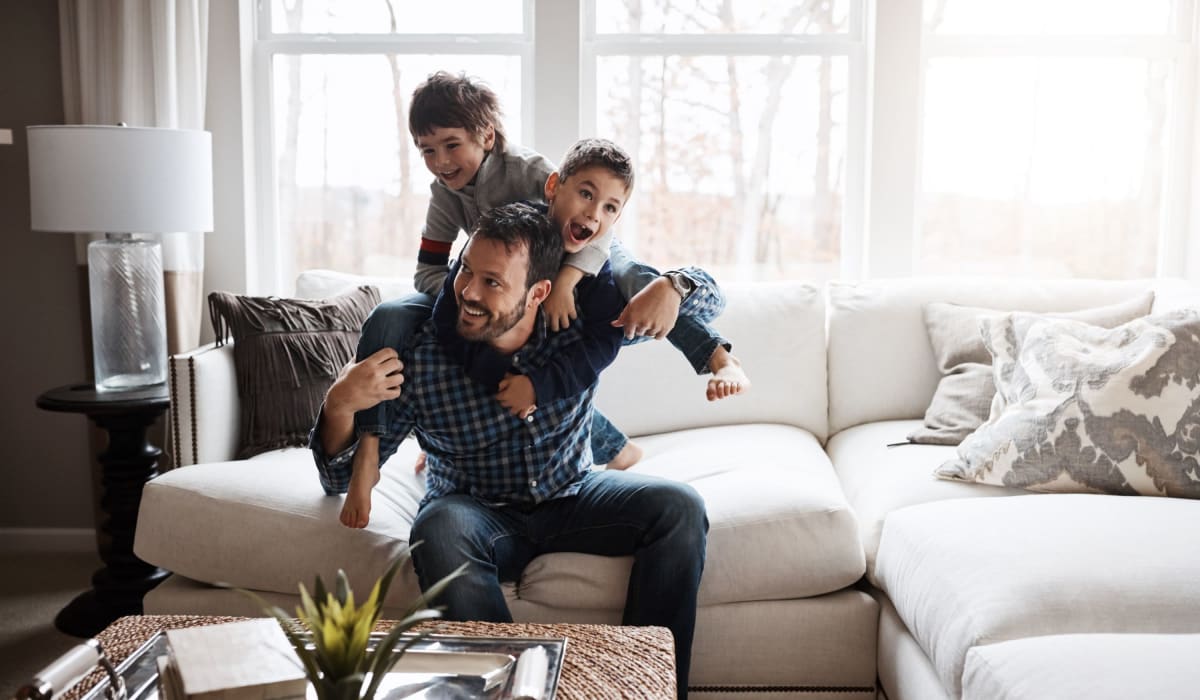 Dad and his two sons playing in their living room at Devi at Valley Ranch in Irving, Texas